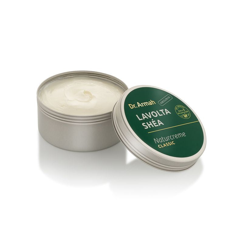 Geöffneter Tiegel der Dr. Armah Lavolta Shéa Naturcreme Classic, der die cremige Textur zeigt, mit dem Deckel angelehnt.