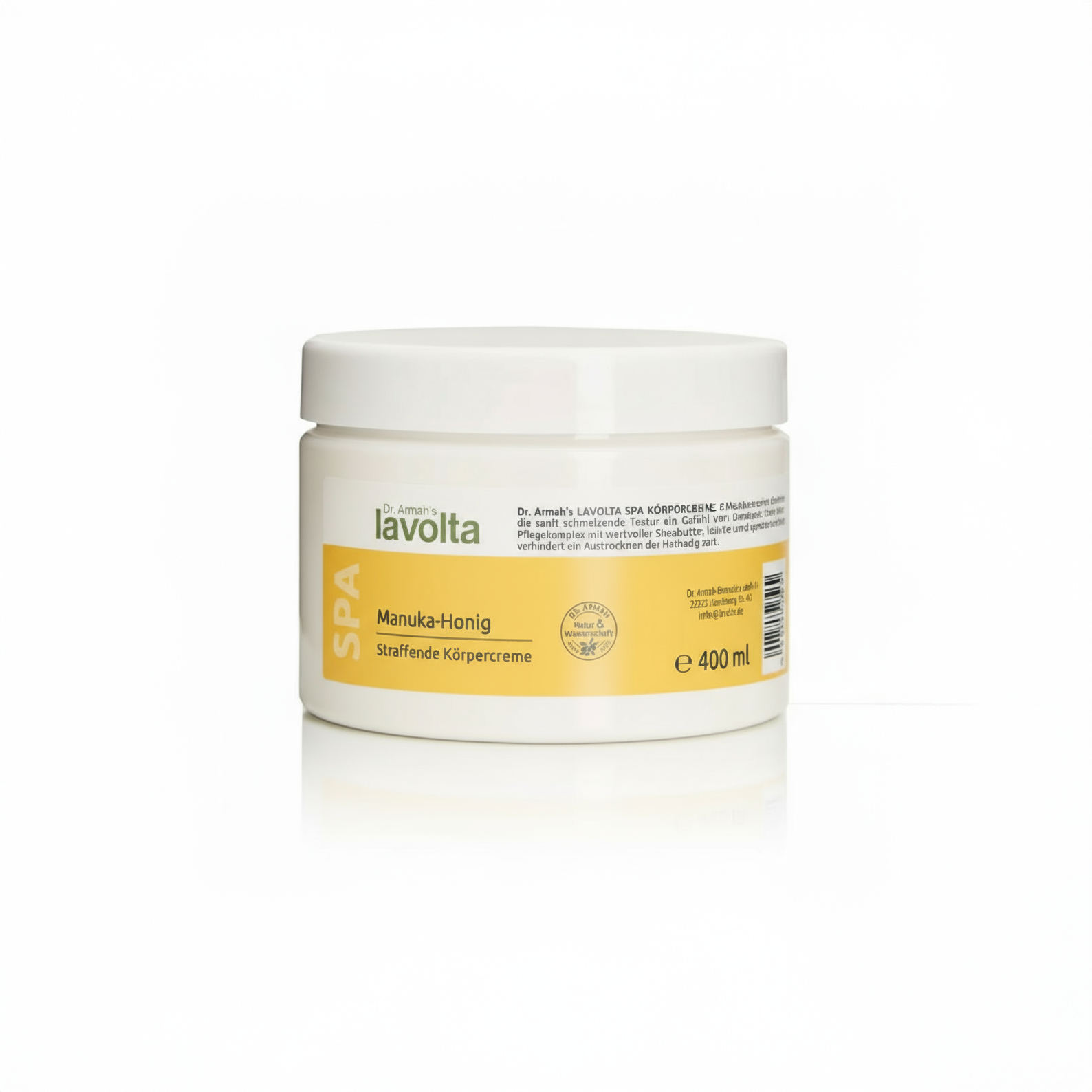 Ein professionelles Produktfoto eines weißen Tiegels "Dr. Armah's lavolta SPA Manuka-Honig Straffende Körpercreme". Der Cremetiegel mit gelbem Etikett steht vor einem reinweißen Hintergrund und spiegelt sich leicht auf der Oberfläche.